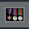 Black picture frame for three military medals with grey mount