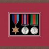 Dark woodgrain picture frame for three military medals with beaujolaismount