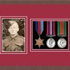Dark woodgrain picture frame for three military medals/photo with beaujolais mount