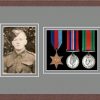 Dark woodgrain picture frame for three military medals/photo with grey mount