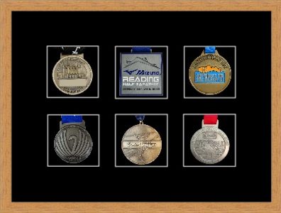 Light woodgrain picture frame for six marathon medals with black mount