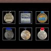 Dark woodgrain picture frame for six marathon medals with black mount