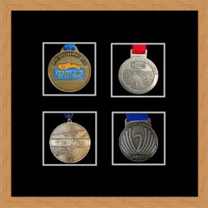 Light woodgrain picture frame for four marathon medals with black mount