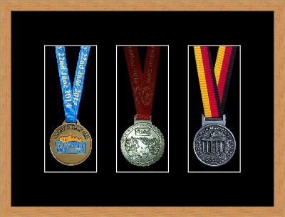 Light woodgrain picture frame for three marathon medals with black mount